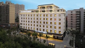 A multi-story hotel with a prominent sign, large windows, and a flat roof. - Fairfield by Marriott Haikou Meilan (Haikou)