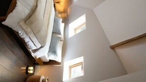 A bedroom with a bed, pillows, a nightstand, and a window. - Charming 2-bedroom cottage with WiFi, AC in serene Miller Beach, IN (Gary)