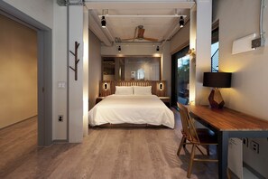 A modern bedroom with a large bed, wooden headboard, bedside tables, a desk with a chair, and a ceiling fan. - L9 Tailor Serviced Home near Hongik Univ (Seoul)