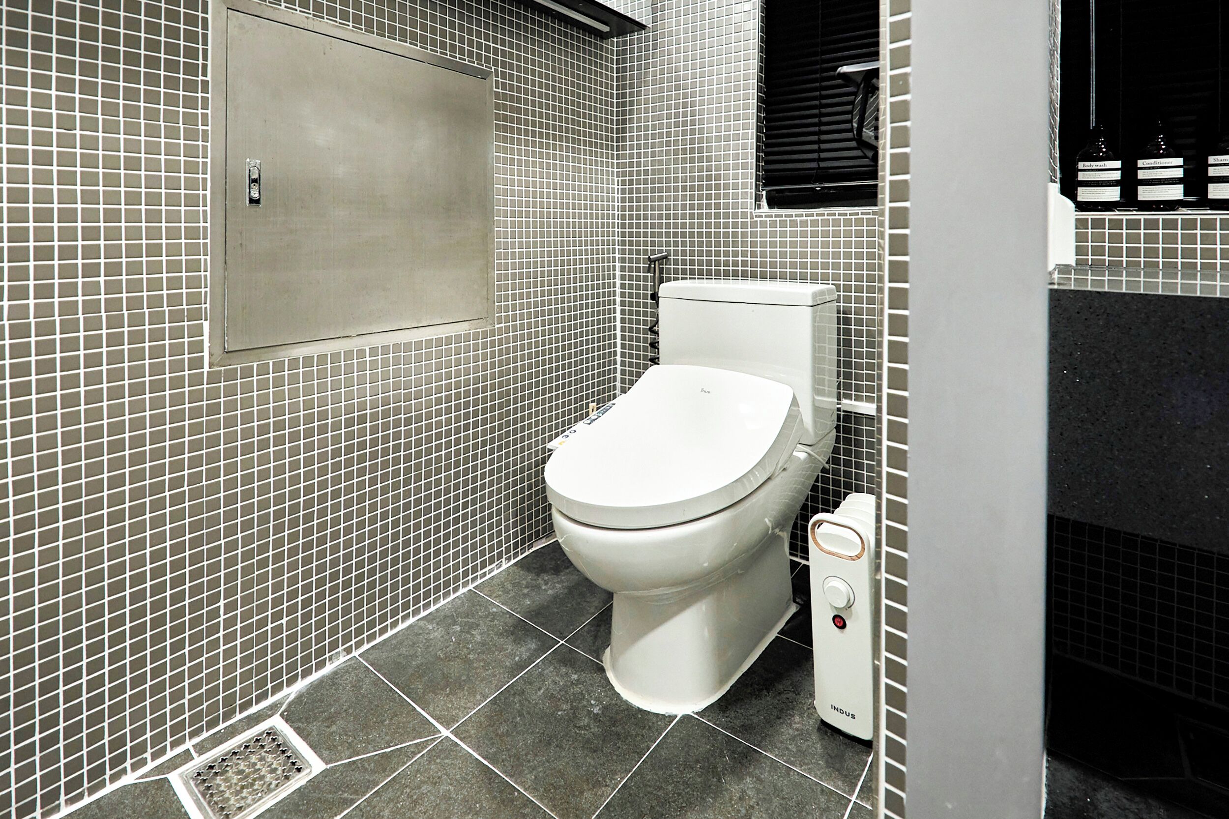 A bathroom with a toilet, a bidet, and a tiled floor.