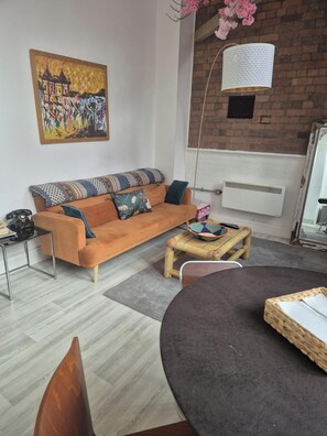 Relax in this inviting living room with a comfortable sofa, a small table, and a beautiful painting.