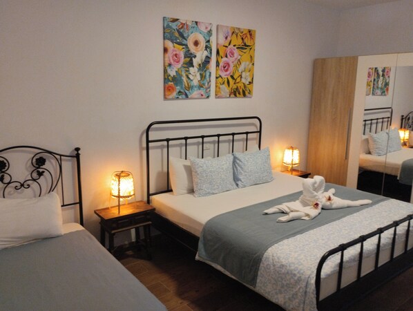 Un dormitorio con una cama individual, dos mesitas de noche y dos cuadros colgados en la pared.