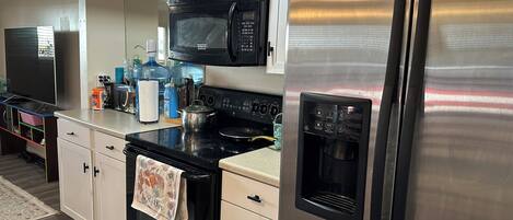 A modern kitchen with stainless steel appliances, a microwave, an oven, and a refrigerator.