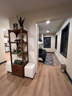 Een moderne woonkamer met houten vloer, een bank, een bijzettafeltje en een boekenkast.