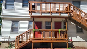 A two-story building with a wooden staircase and balcony.