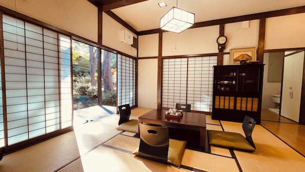 A traditional Japanese room with tatami flooring, sliding shoji doors, a low table with a tea set, and a dark wooden cabinet. - Hakone 【 Secret Garden 】 Resort&Onsen 【 Secret Garden】 Sengokuhara Onsen Villa|Party|Reunion|Giant Garden|Parking for 3 cars (箱根町)