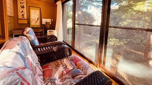 A traditional Japanese room with tatami mats, a low table, and a large window with a view of a forest. - Hakone 【 Secret Garden 】 Resort&Onsen 【 Secret Garden】 Sengokuhara Onsen Villa|Party|Reunion|Giant Garden|Parking for 3 cars (箱根町)