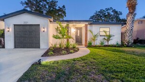 Une maison de plain-pied avec un garage, située au numéro 2221, et une pelouse bien entretenue agrémentée de palmiers.