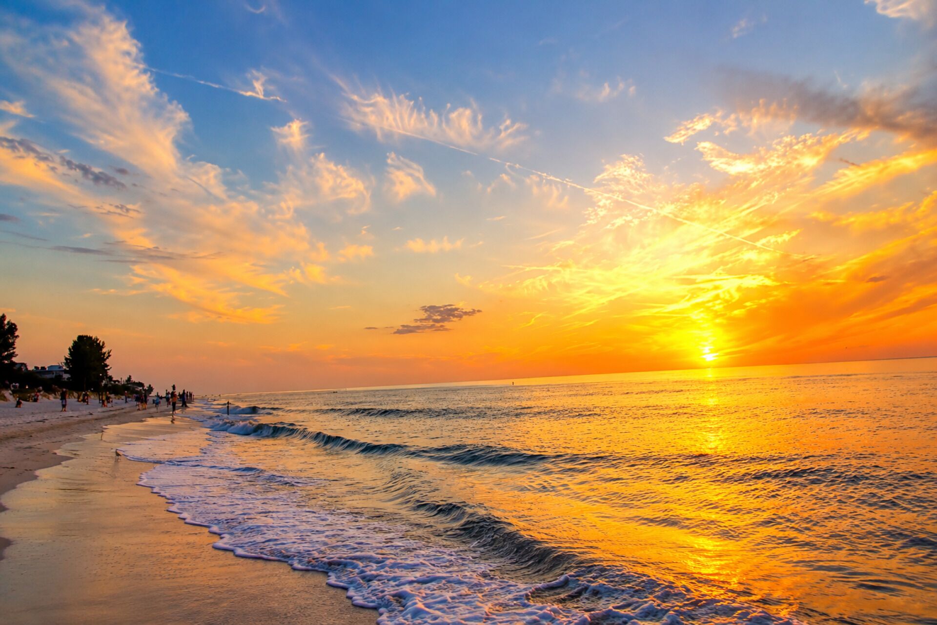 Een strand met golven en een zonsondergang.