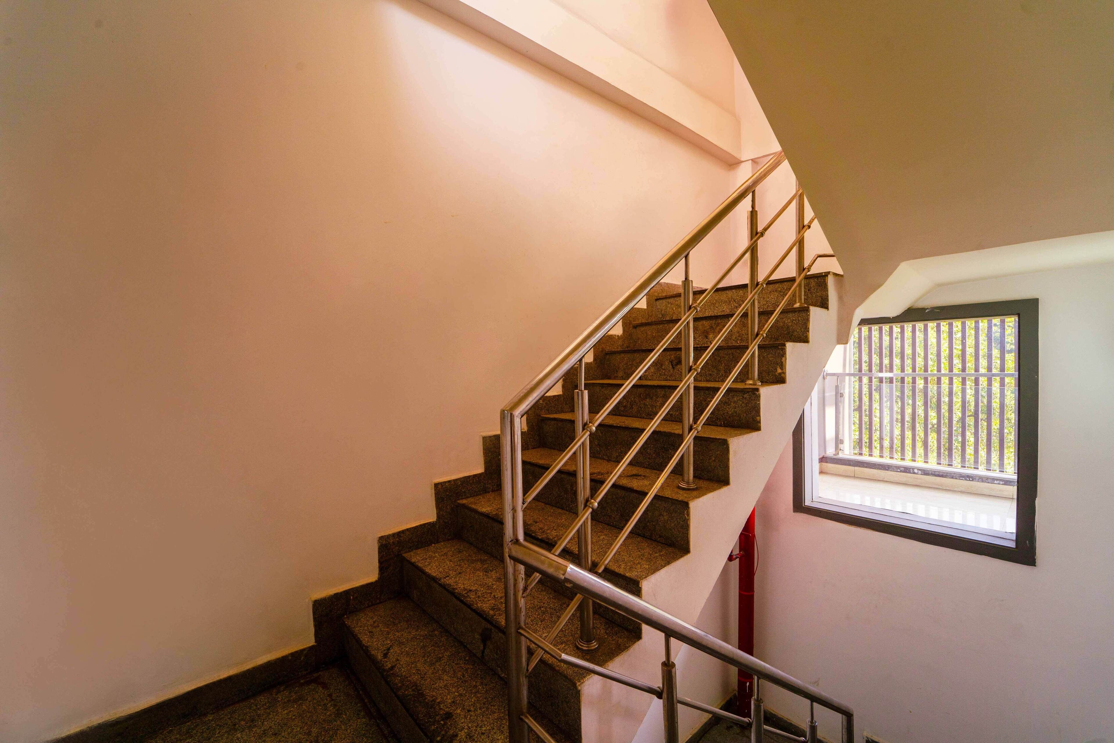A staircase with metal railings and a window with a view of the outside.