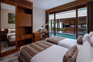 Habitación de hotel con dos camas, un escritorio y vista a una piscina.