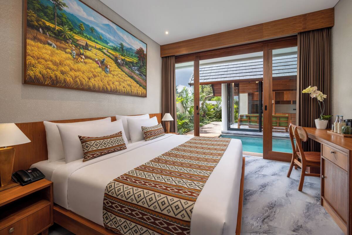 Une chambre d’hôtel avec un grand lit, un bureau et une vue sur la piscine.