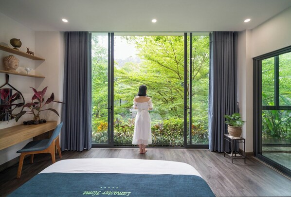 A bedroom with a large window, a bed, a desk, and a chair. - Lamaster Homes F1.8 Venus Resort (Phuc Yen)