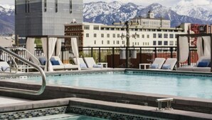 A swimming pool with lounge chairs and a mountainous backdrop.