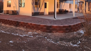 Een huis met twee verdiepingen, een overdekte patio en een gevel van baksteen.