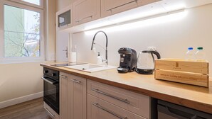 A modern kitchen with a built-in oven, a coffee maker, and a kettle on the counter. - Arcano | Studio dla Dwojga | Przytulne wnętrze (Bydgoszcz)