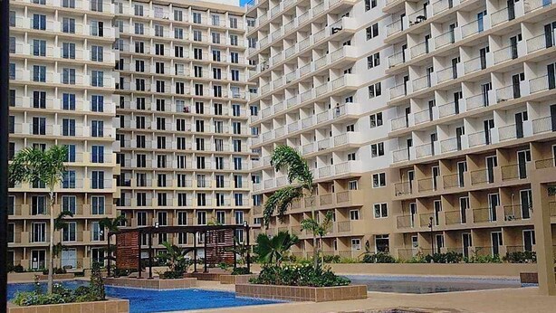 Un hôtel à plusieurs étages avec une piscine en premier plan.