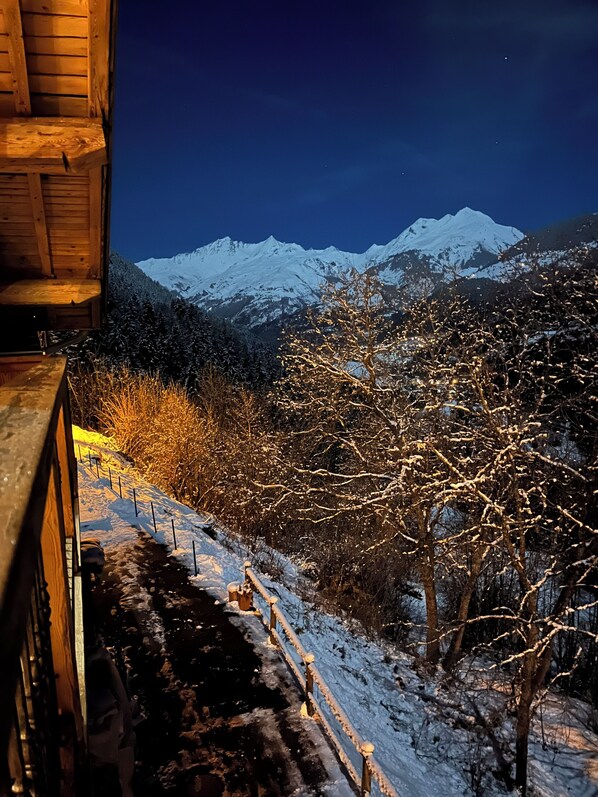 A snowy mountain landscape with a wooden cabin structure.