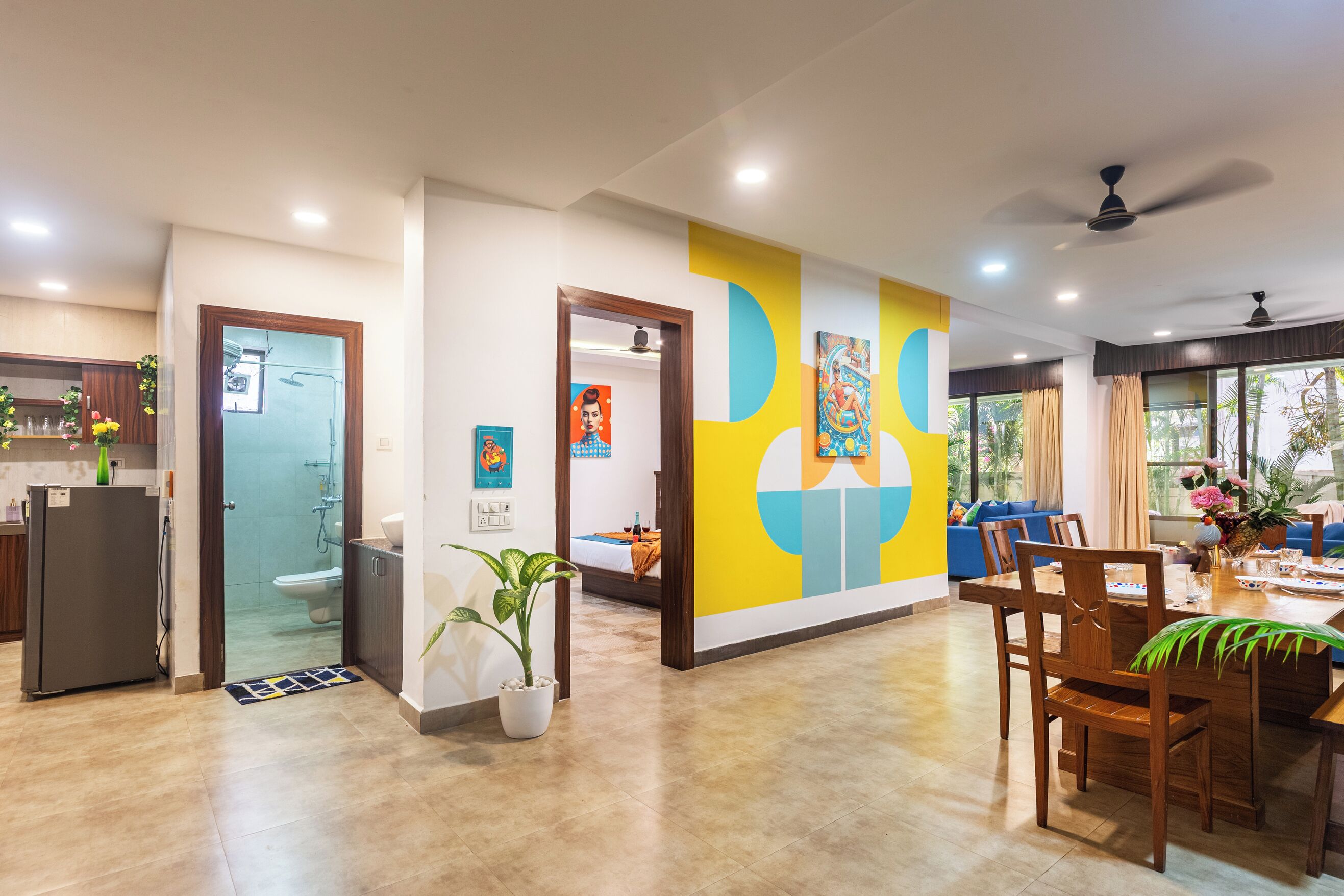 A modern hotel room with a dining area, a bathroom, and a living space.