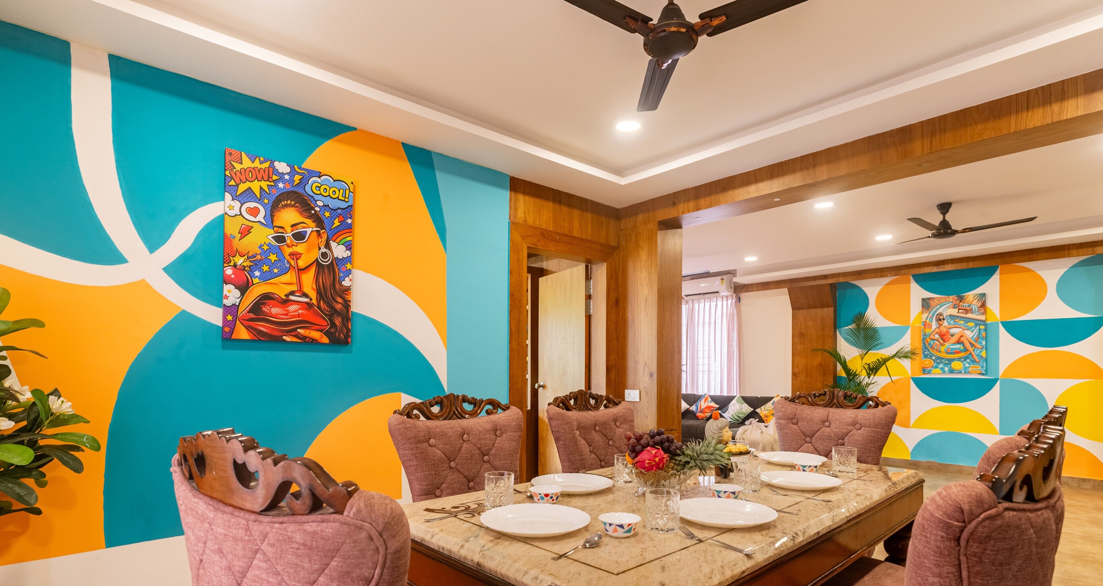 A dining area with a long table, chairs, and a ceiling fan.