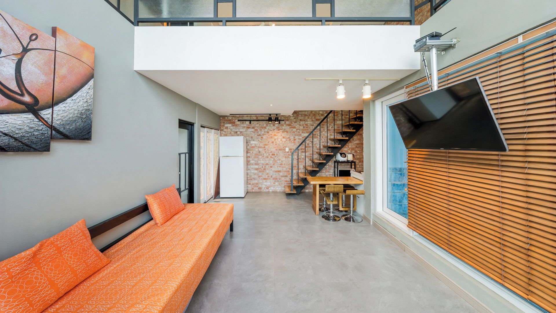 Un interior moderno con sofá, zona de comedor y cocina.