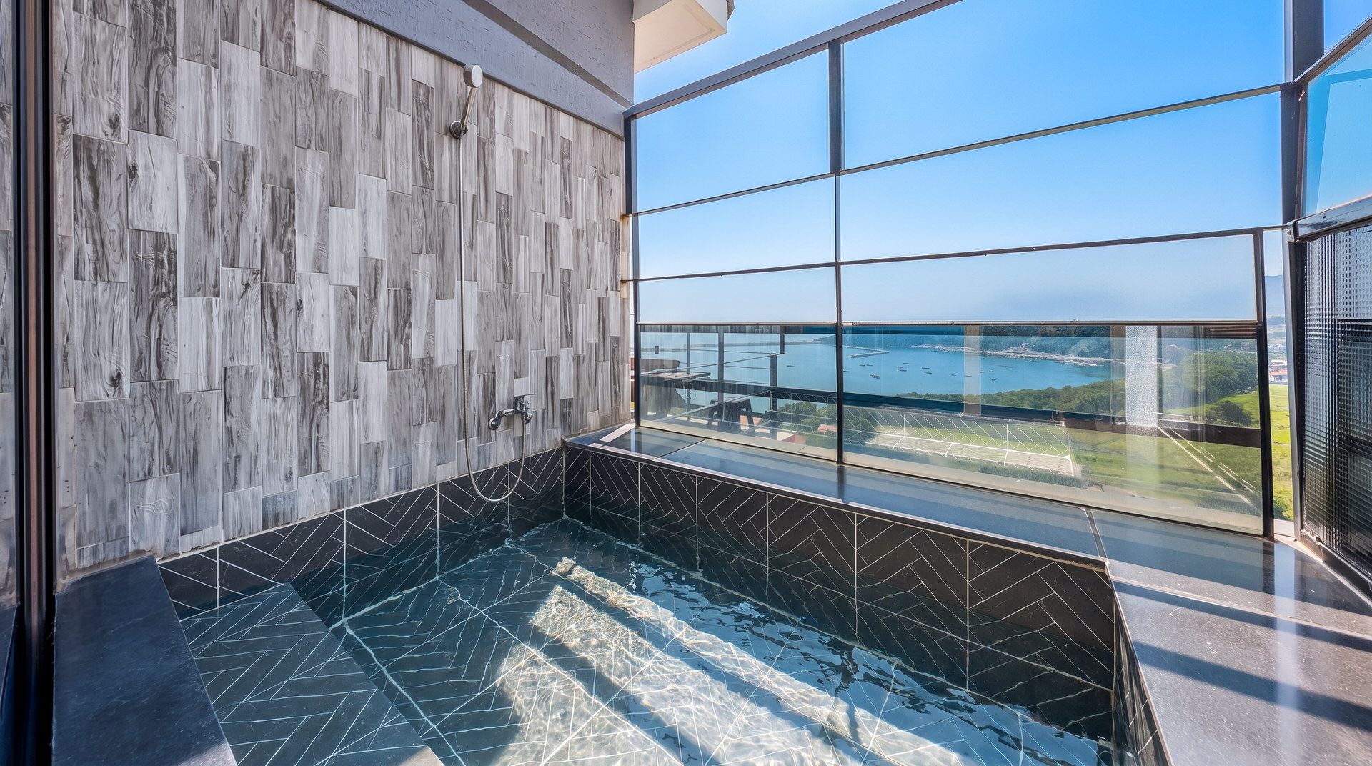 Une salle de bain moderne avec une grande fenêtre, un mur en bois et un sol carrelé.