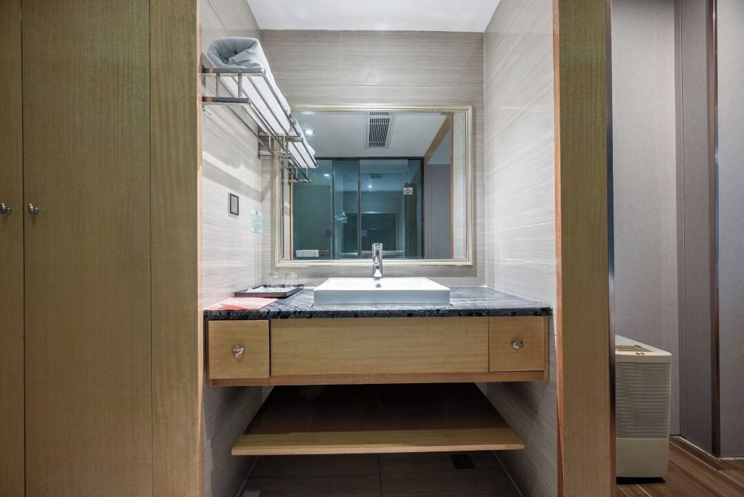 Ein modernes Badezimmer mit integriertem Waschbecken, einem Spiegel und einem Handtuchhalter.