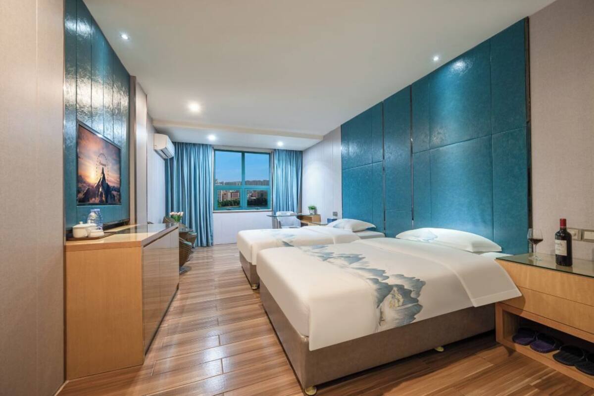 Une chambre d’hôtel moderne avec un grand lit, un bureau et une vue sur le paysage urbain.