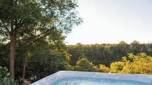 Banyera d'hidromassatge envoltada de vegetació i arbres frondosos.