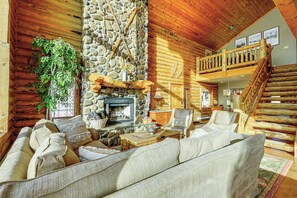 A log cabin interior with a stone fireplace, wooden furniture, and a balcony. - 10 Mi to Deer Valley: Mtn-View Gem w/ Game Room (Park City)