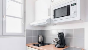 A compact kitchen with a microwave, coffee maker, and a window. - Jardin des Plantes View Studio w/ High-Speed WiFi (Paris)
