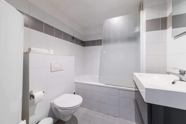 Une salle de bain moderne équipée de toilettes, d’une douche et d’un lavabo.