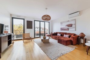 Una sala de estar moderna con un sofá, una mesa de centro y un ventanal grande.
