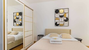A bedroom with a bed, a mirror, a wardrobe, and two wall art pieces. - Studio agreable et bien placee - Paris 18 - 2P (Paris)