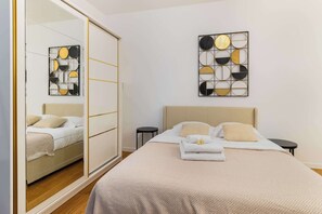 Ein Schlafzimmer mit einem Bett, einem Spiegel, einem Kleiderschrank und zwei Wandbildern.
