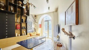 A modern living room with a sofa, a coffee table, a TV, and a fireplace.