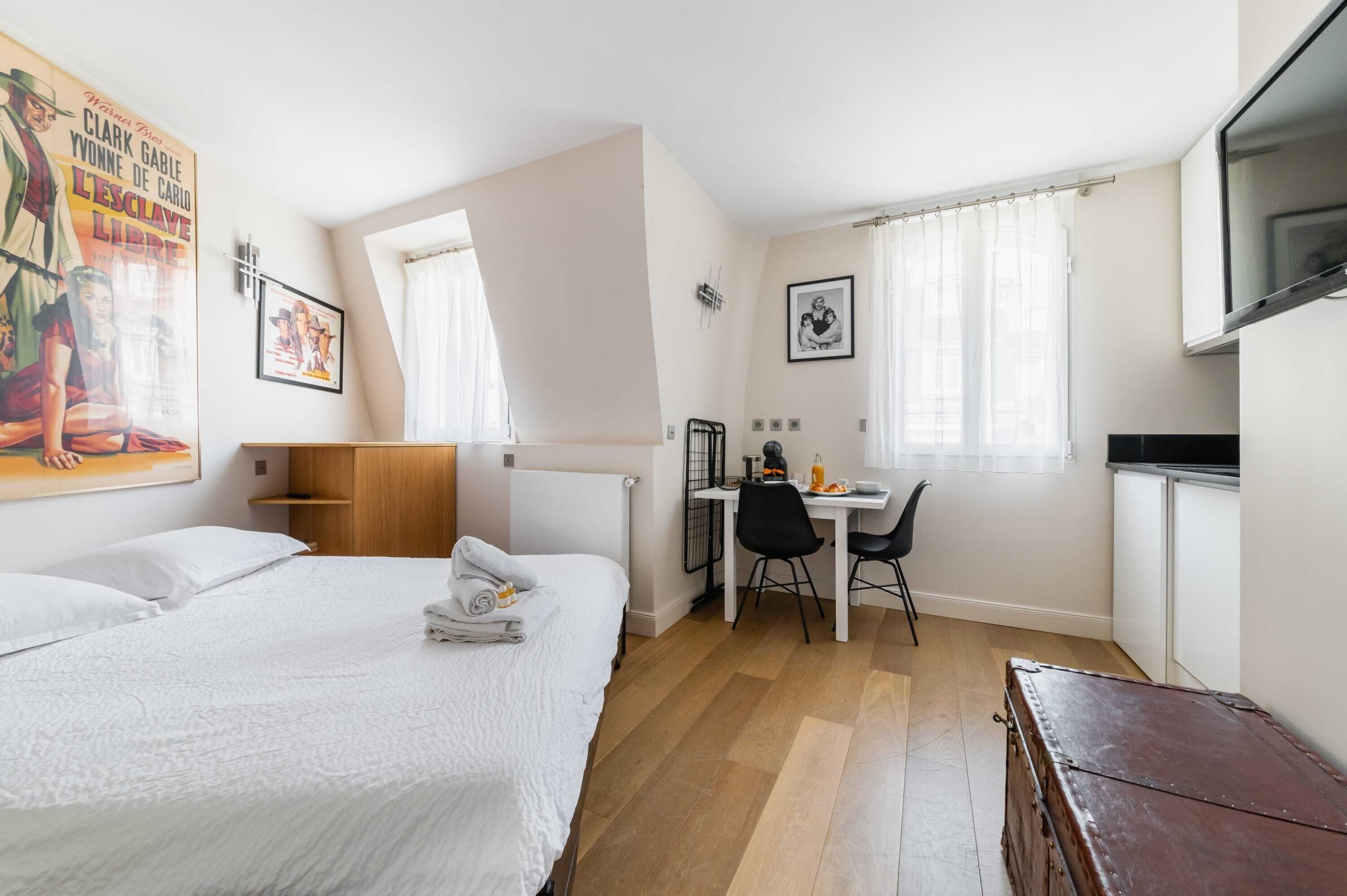 Una habitación de hotel con cama, escritorio, silla y televisión.