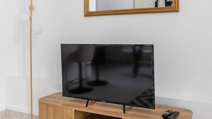 Ein Fernseher auf einer Holzkommode, darüber ein Spiegel.