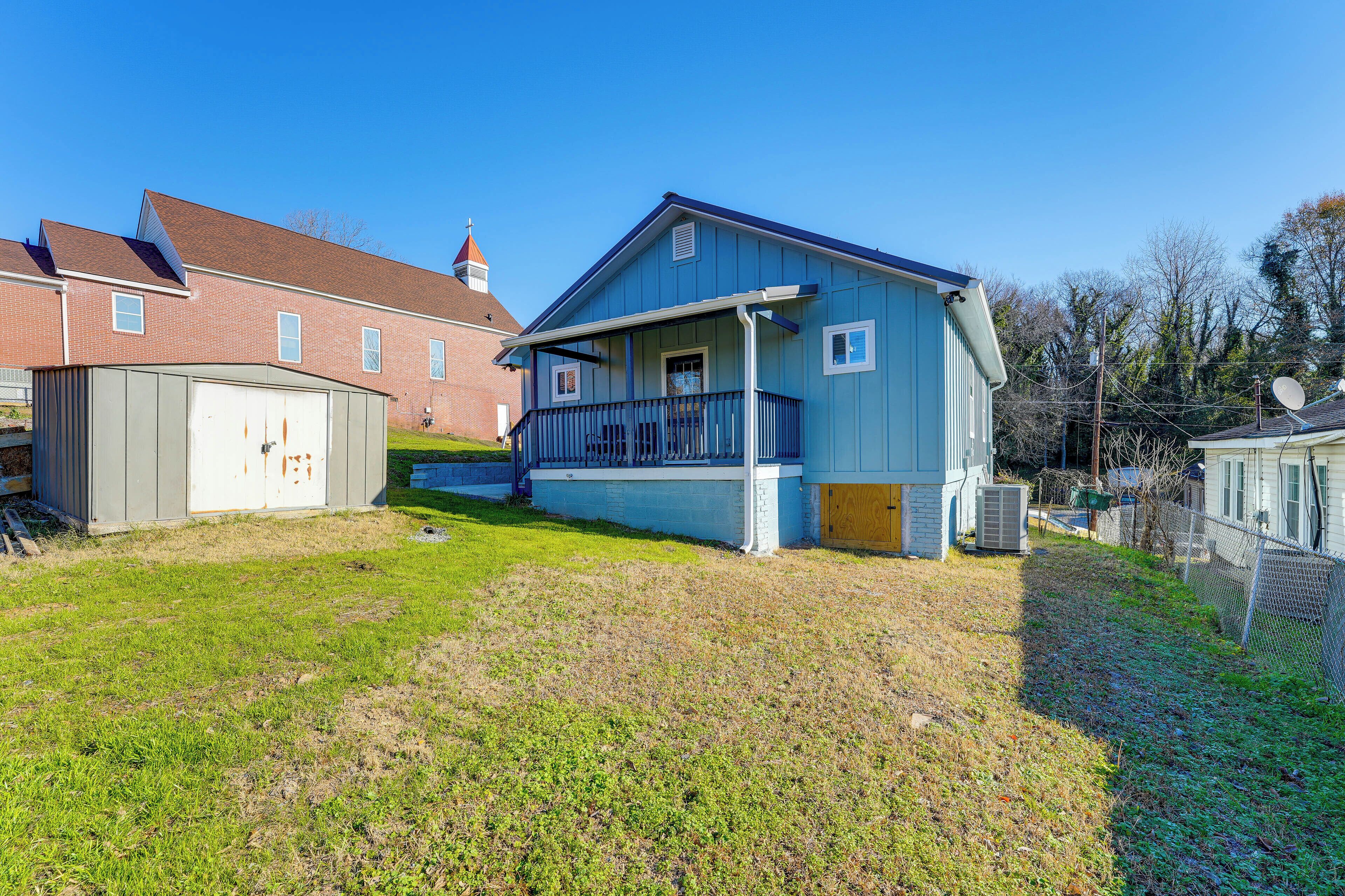Ein Wohngebiet mit einem blauen Haus, das eine Veranda und eine Garage hat.