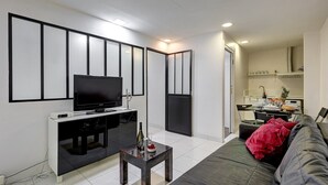 Una sala de estar moderna con un televisor de pantalla plana, una mesita de centro y un sofá.