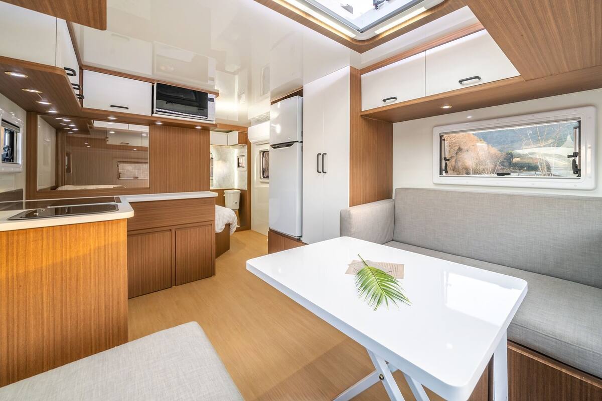 Une cuisine compacte avec des meubles en bois, un plan de travail blanc et un four encastré.