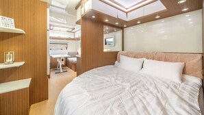 A compact, well-lit bedroom with a bed, bedside tables, and a small desk area. - Goseong Hoostay Caravan Pension (Goseong)