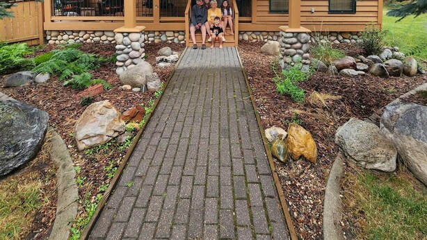 Eine Lodge mit Steinfundament, Holzfassade und einer Veranda.
