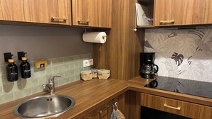 A kitchen with wooden cabinets, a stainless steel sink, a Bosch dishwasher, and a coffee maker.