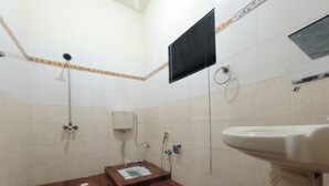 A bathroom with a wooden floor, a white sink, a shower, and a toilet. - Room-serene Guest Room Retreat in Rawalp (Rawalpindi)