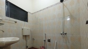 A small bathroom with a toilet, sink, shower, and mop. - Room-cozy Guest Room in Rawalpindi - Sha (Rawalpindi)