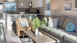 A modern living room with a sofa, a coffee table, and a decorative plant. - Casa do Sol by AvantStay | Rooftop Deck w/ Ocean Views | 2 blocks to Beach! (Pismo Beach)