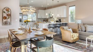 A modern kitchen with white cabinets, a central island, and pendant lighting. - Casa do Sol by AvantStay | Rooftop Deck w/ Ocean Views | 2 blocks to Beach! (Pismo Beach)