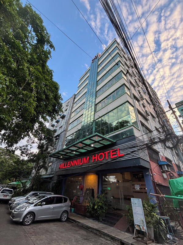 Ein hohes Hotelgebäude mit Glasfassade und einem Schild mit der Aufschrift 'Millennium Hotel'.