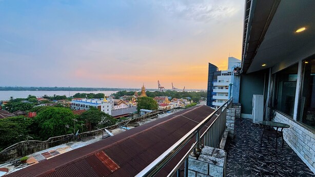 Un balcone con vista su un paesaggio urbano, che include edifici e un fiume.